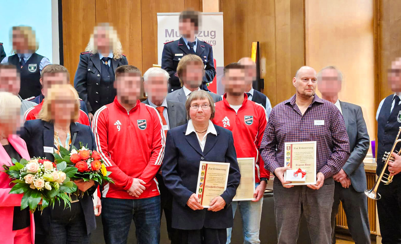 Eine Gruppe an Menschen, aus verschiedenen Vereinen. Roman und Elisabth vorne in der Matte, sie halten Urkunden in der Hand.